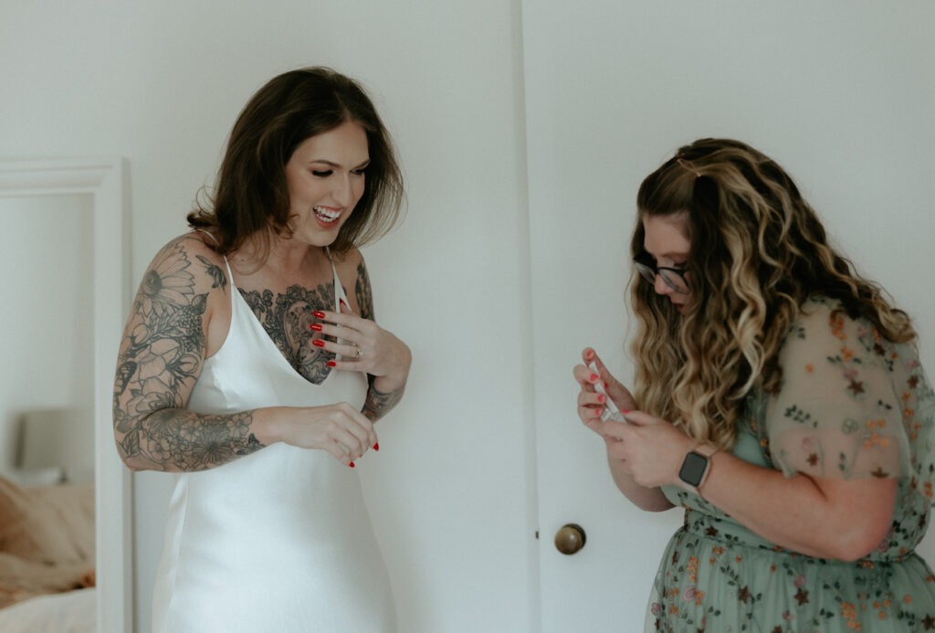 A woman helping her sister put on her jewelry. 