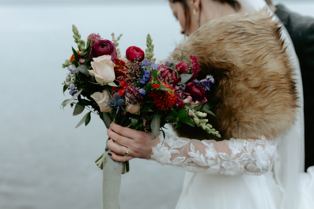 Woman holding a colorful bouquet of flowers. 