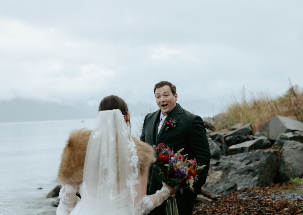 Man smiling as he see's his bride for the first time. 