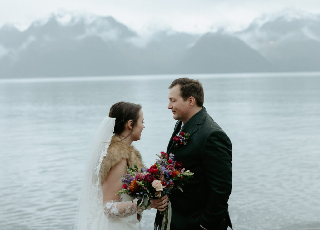 Couple holding onto one another while surrounded by the mountains. 