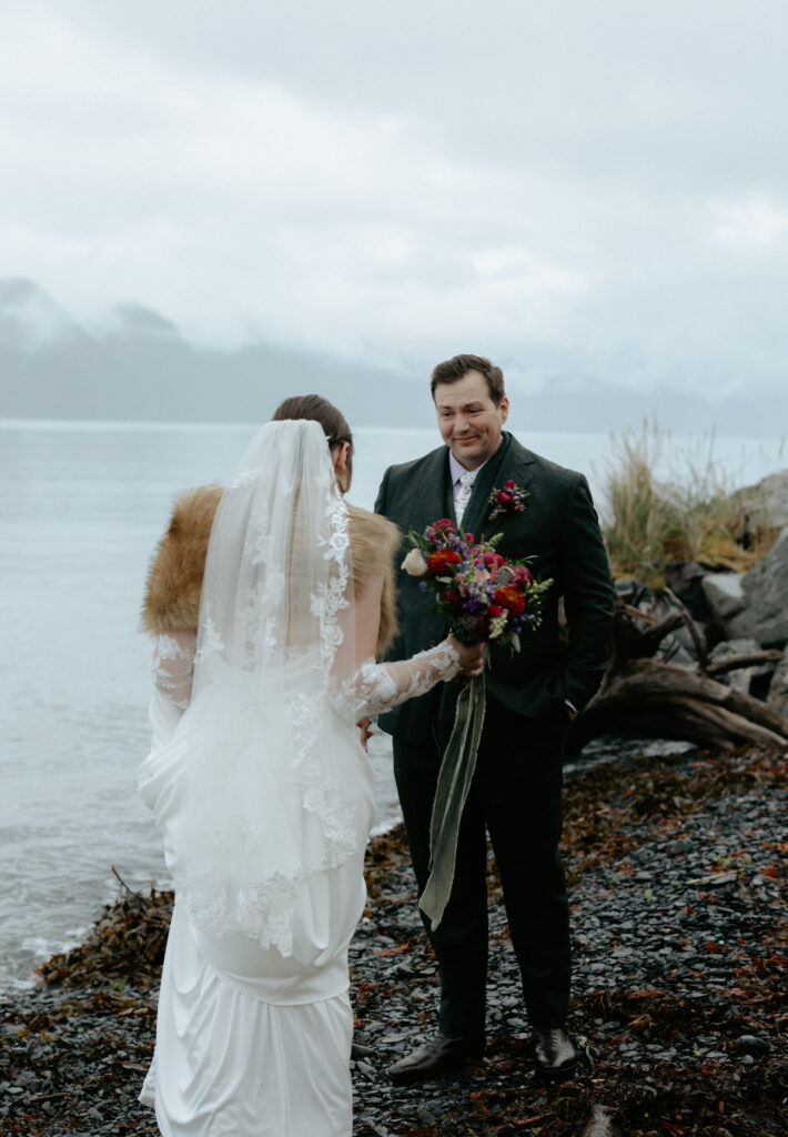 Man smiling at a woman as she wears  a white dress. 