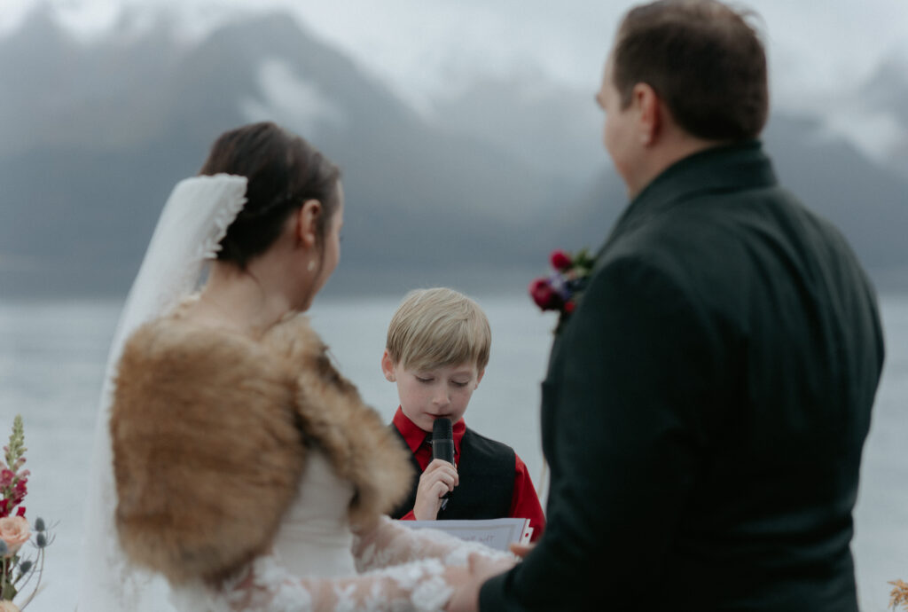 Couple looking at a boy as he reads a message to them. 