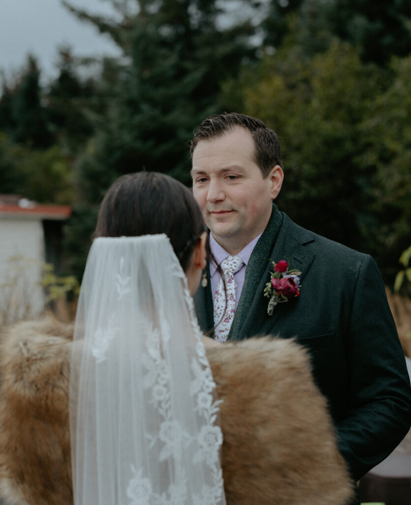 A man looking at a woman while wearing a green suit. 