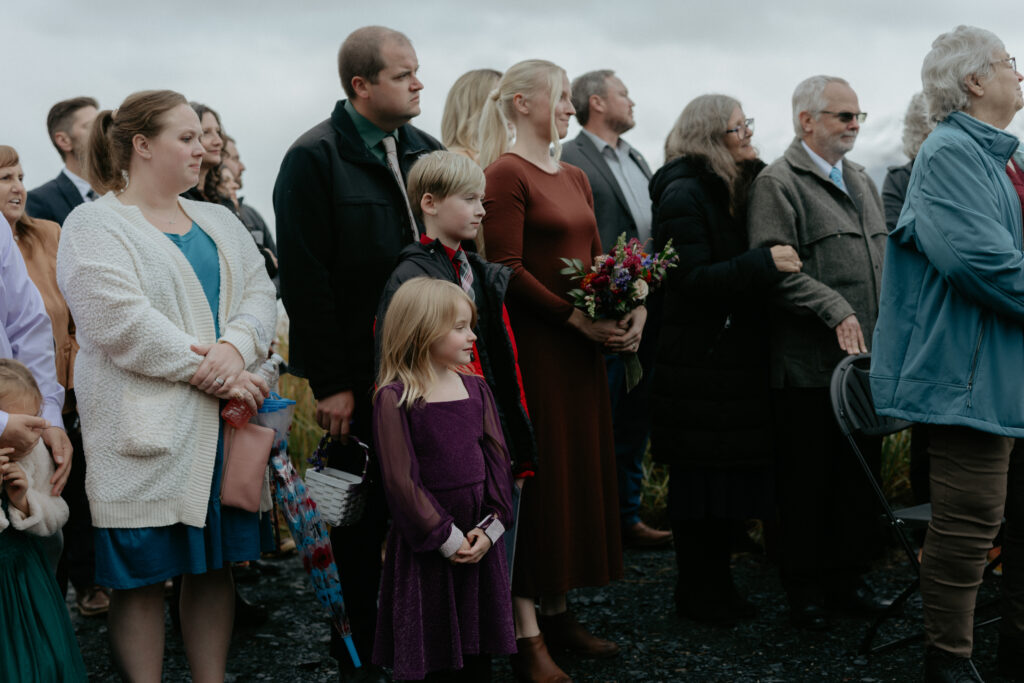 A group of people watching a wedding ceremony. 