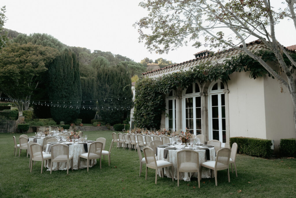 Tables and chairs setup outside of a wedding venue. 