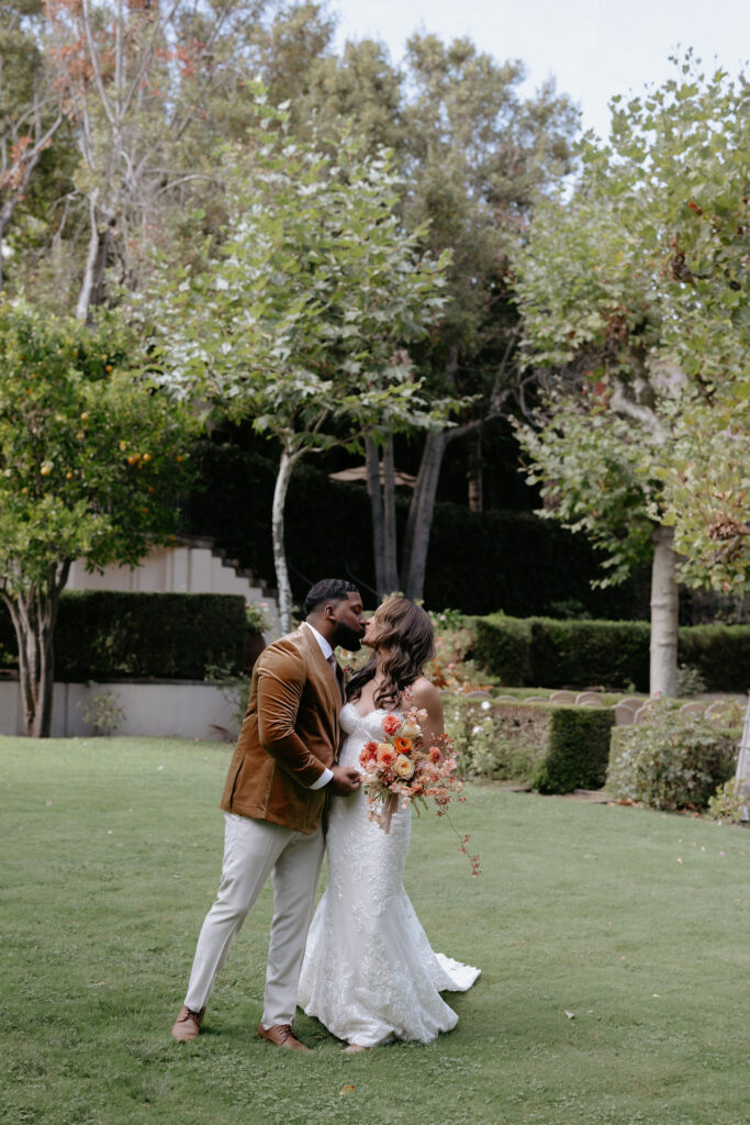 A couple kissing in the middle of a beautiful courtyard space. 