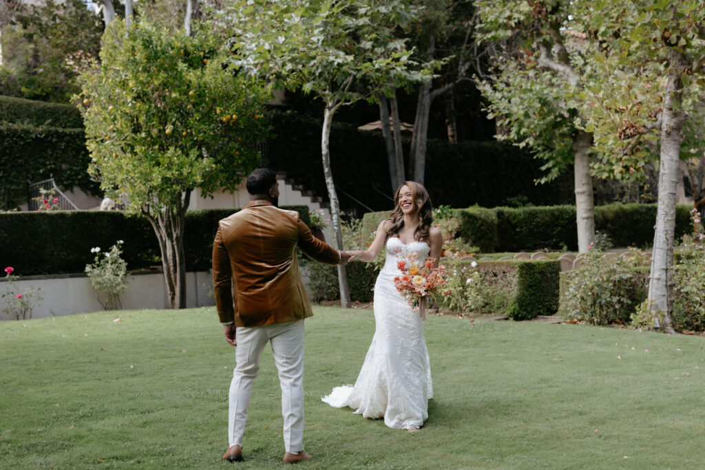 A man holding onto a woman's hand as he guides her through the courtyard.