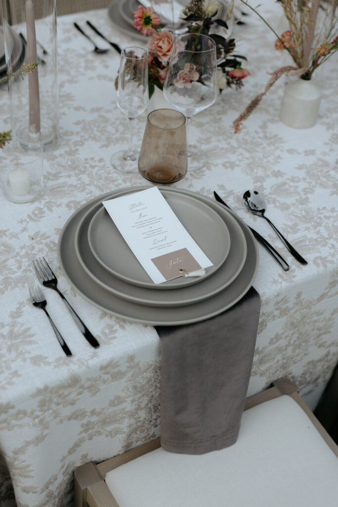 A set of grey plates stacked on top of one another along with a set of silverware on the side.