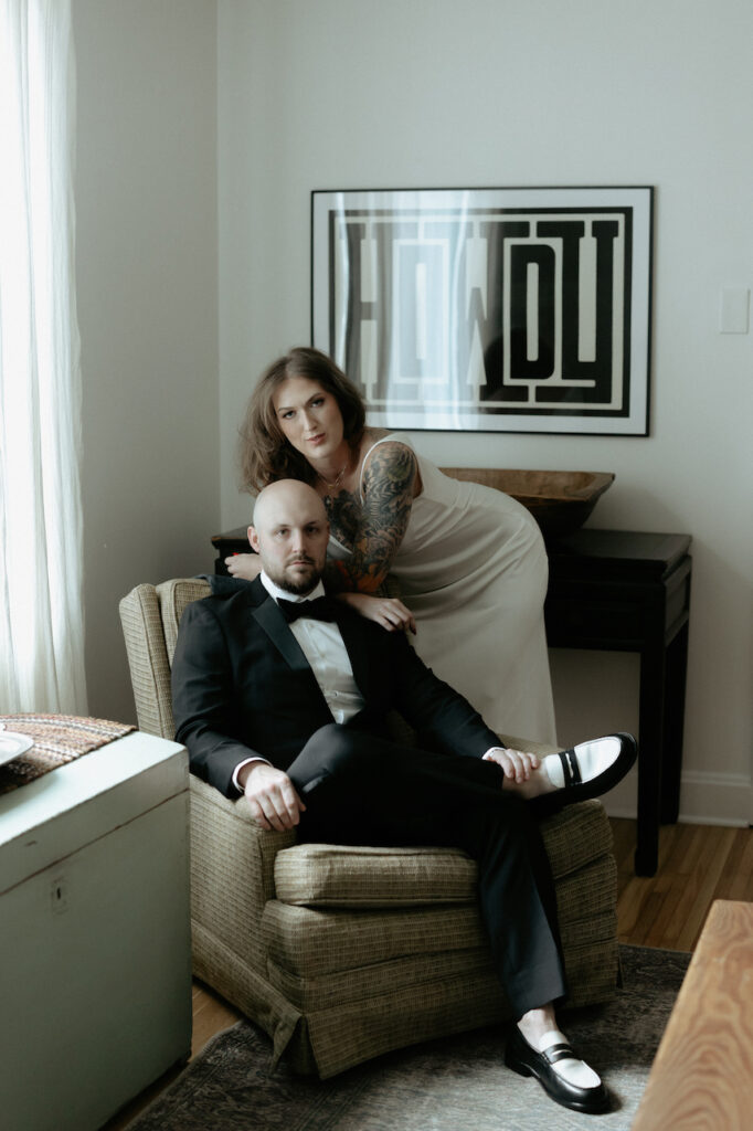 A man sitting in a chair with a woman draped over him. 