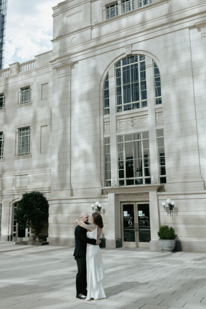 A couple standing in front of the Symphony building. 