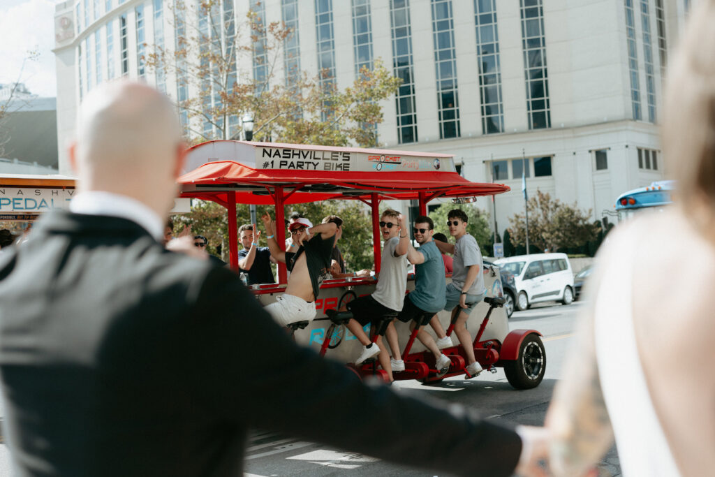 A beer trolley passing by a couple during a walk in downtown. 