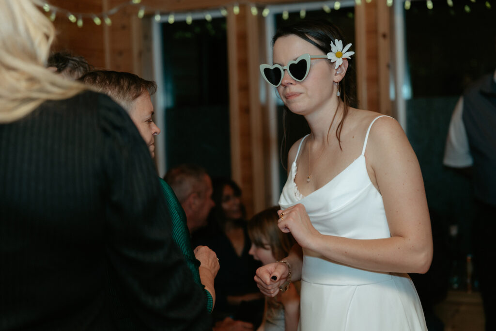 Woman wearing heart shaped sunglasses and dancing.