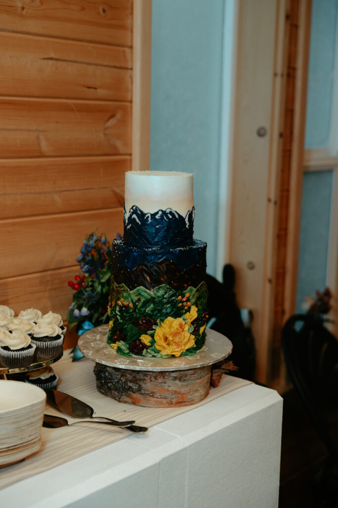 A three tier cake placed on a wooden structure. 