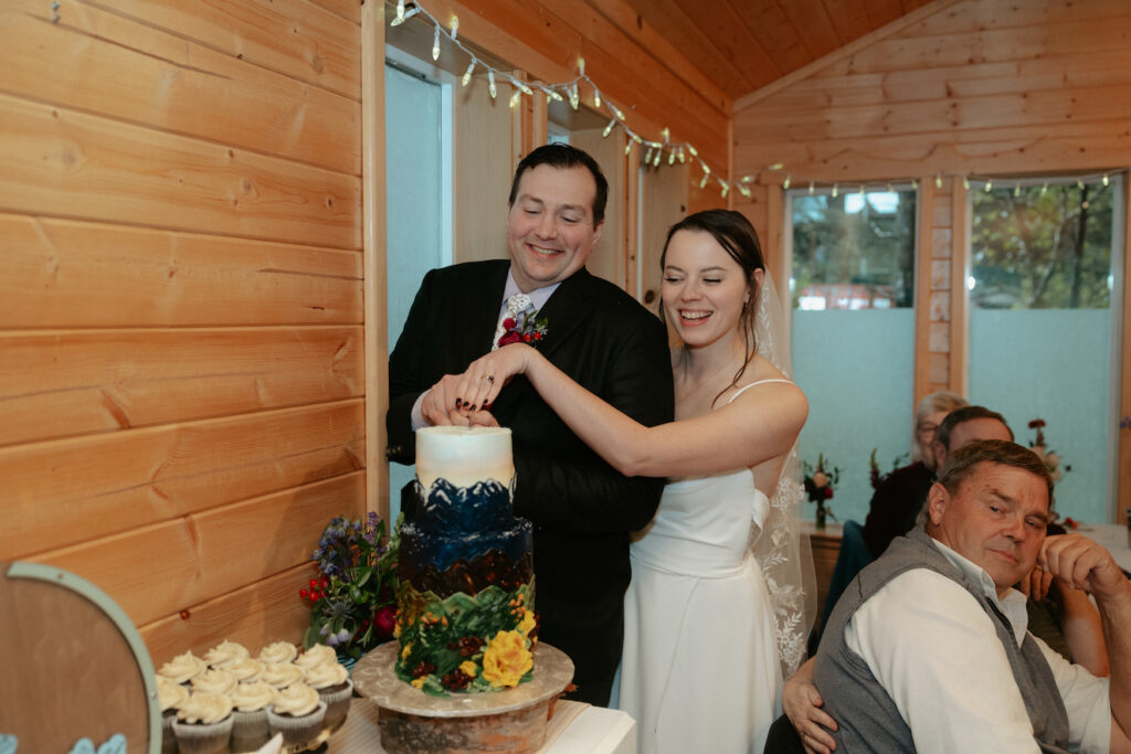 Couple smiling and cutting a cake together. 