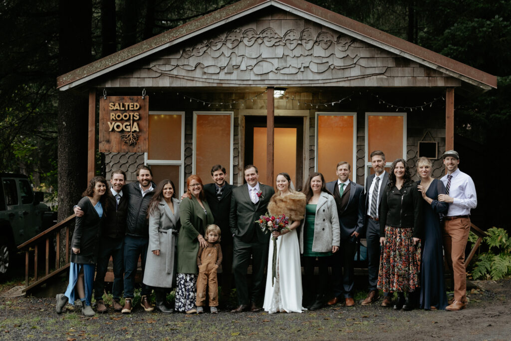 A group of people standing in front of a wooden cabin.