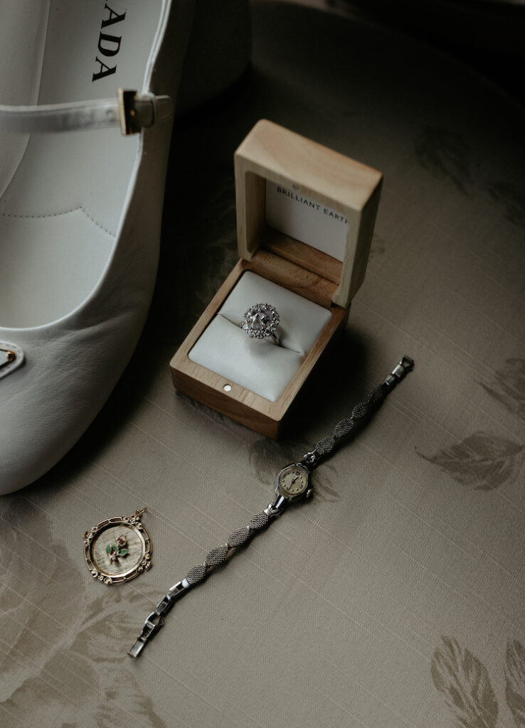 A ring in a wooden box placed on a vintage chair cushion. 