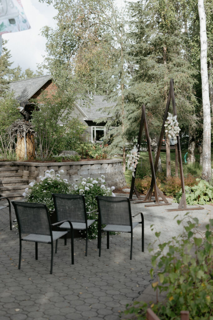 A wooden arch with pink and white florals attached to it. 