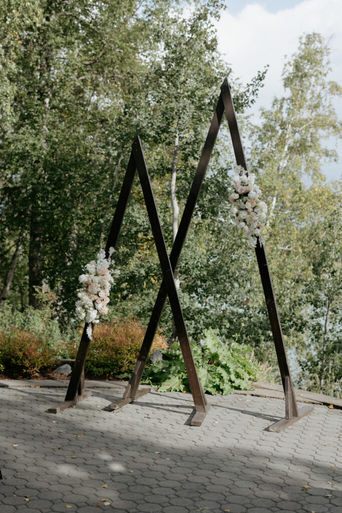 A wooden arch surrounded by trees. 