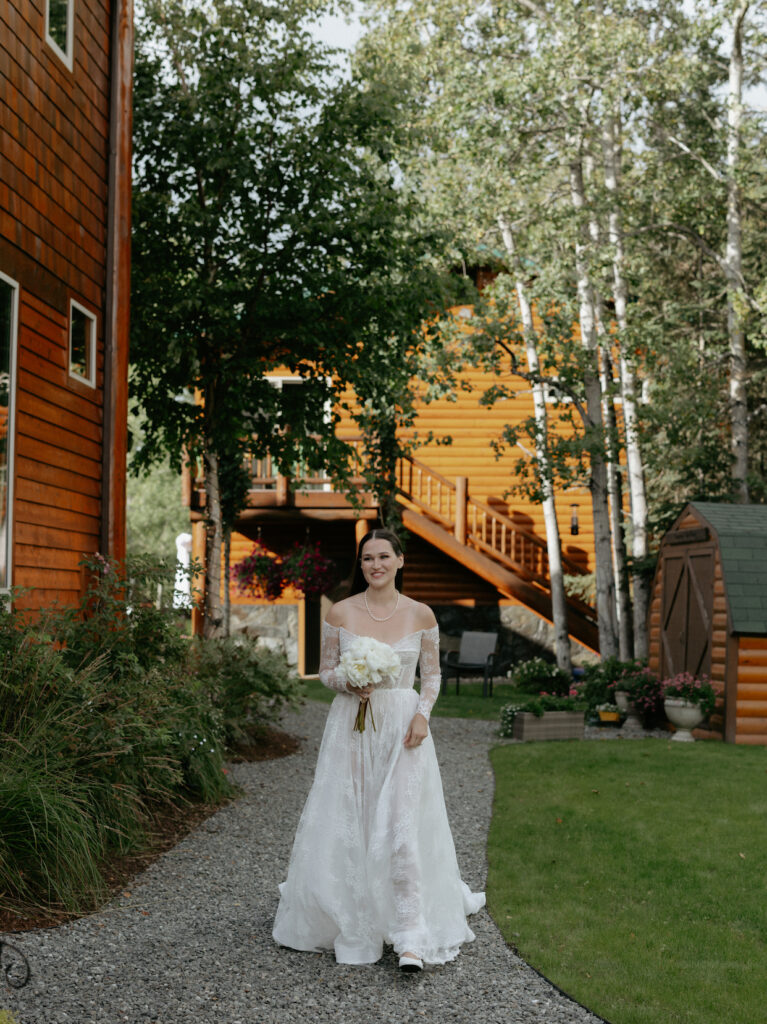 A woman wearing a white dress walking along a path. 