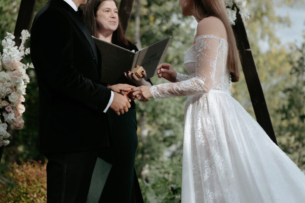 A man placing a ring on a woman's finger. 