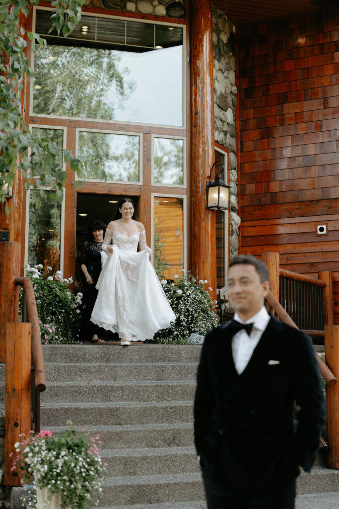 A woman wearing a white dress and walking down a set of stairs. 