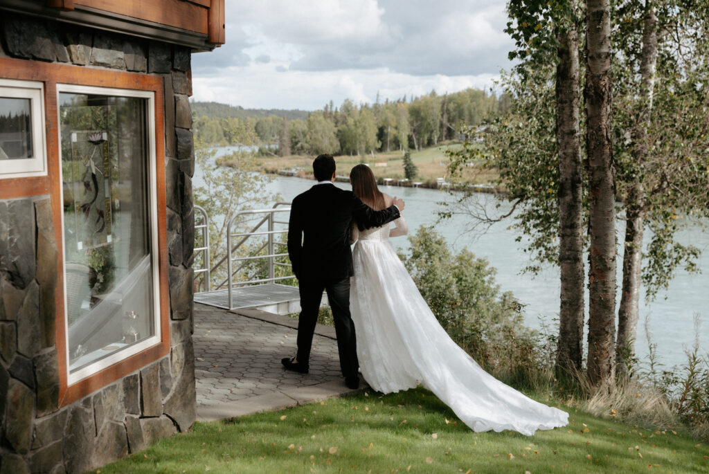 A man wrapping his arm around a woman wearing a white dress. 