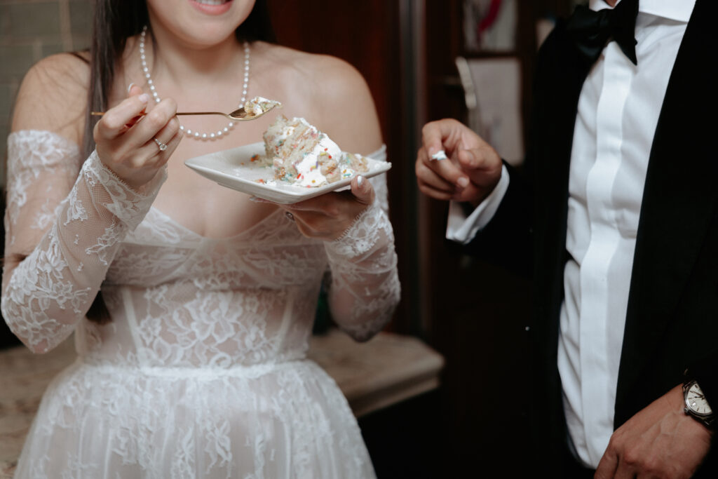 A woman eating a slice of wedding cake. 