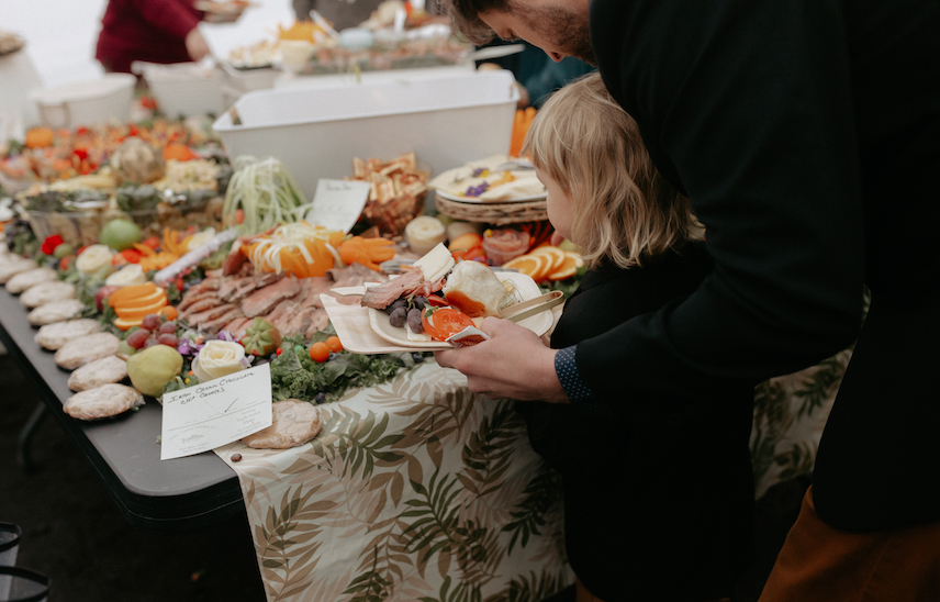A boy and his father grabbing cured meats and cheeses during a wedding reception in Seward, Alaska. 