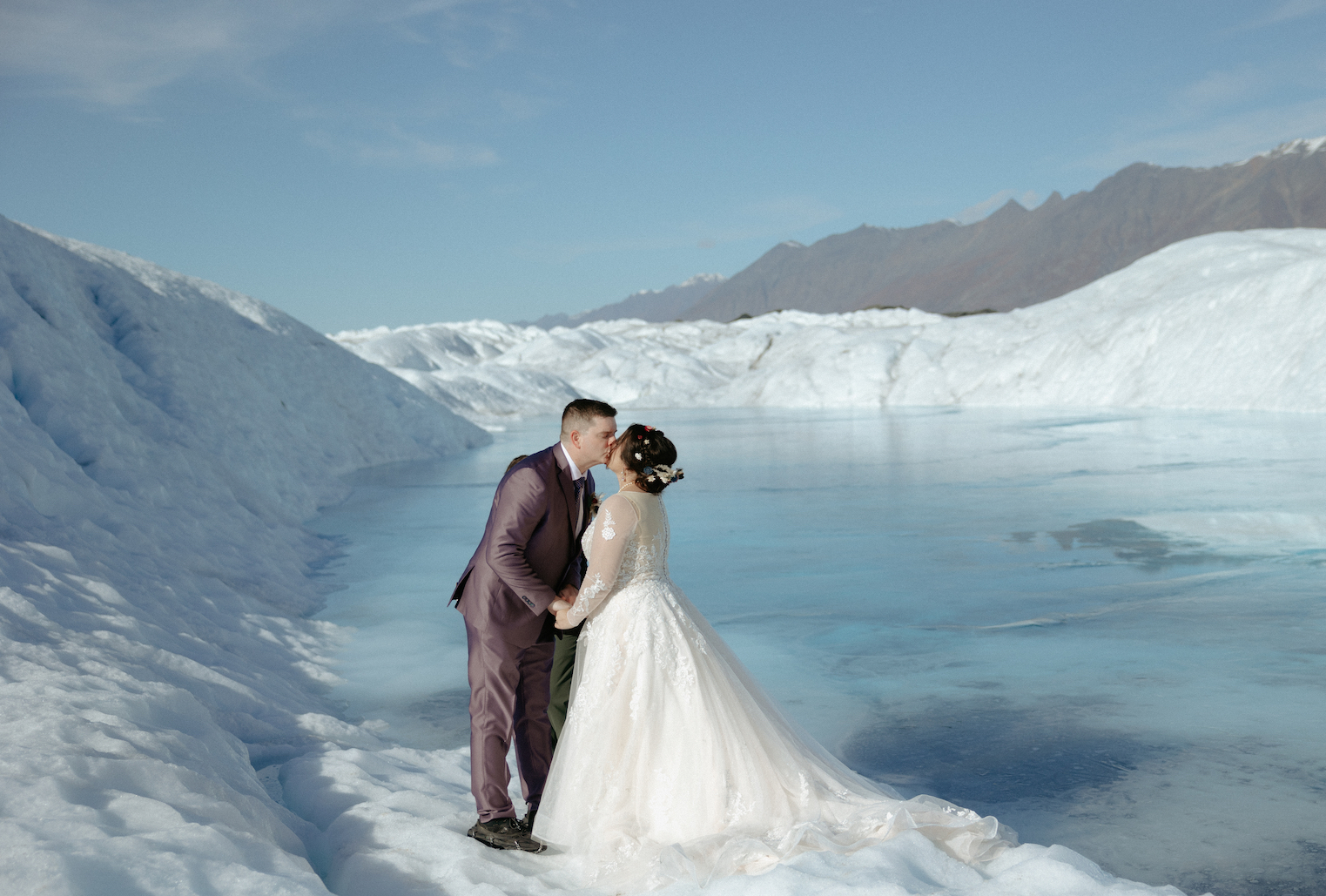 A couple kissing on a glacier after getting married in Alaska. 