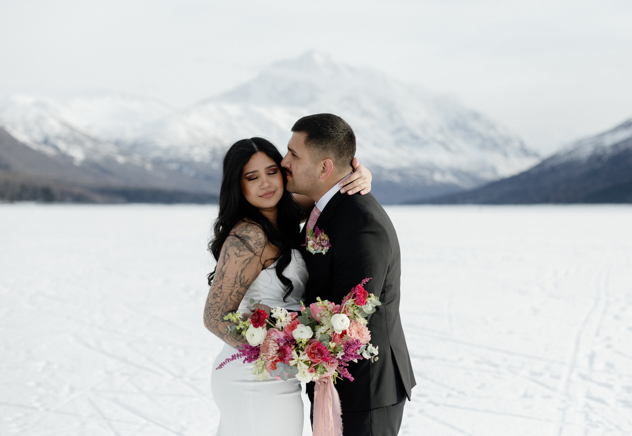 A couple embracing at Eklutna Lake a wedding location in Alaska.