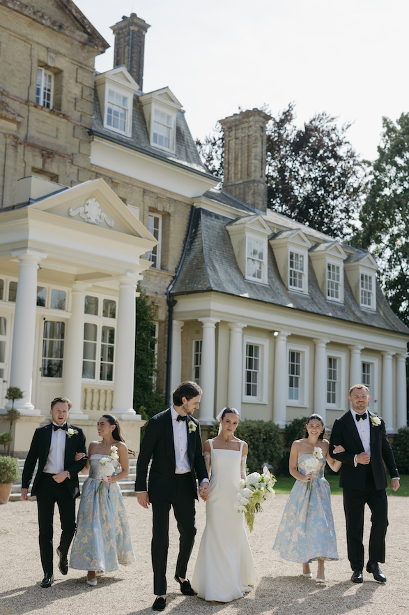 A bridal party walking away from the venue. 