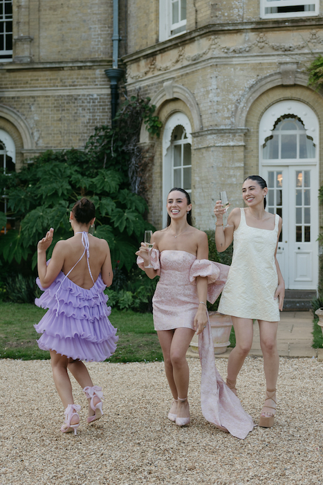 A group of girls dancing and making videos in front of the venue.