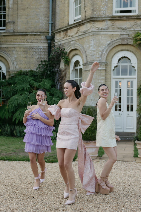 A group of girls in colorful dresses dancing in front of Pylewell Park