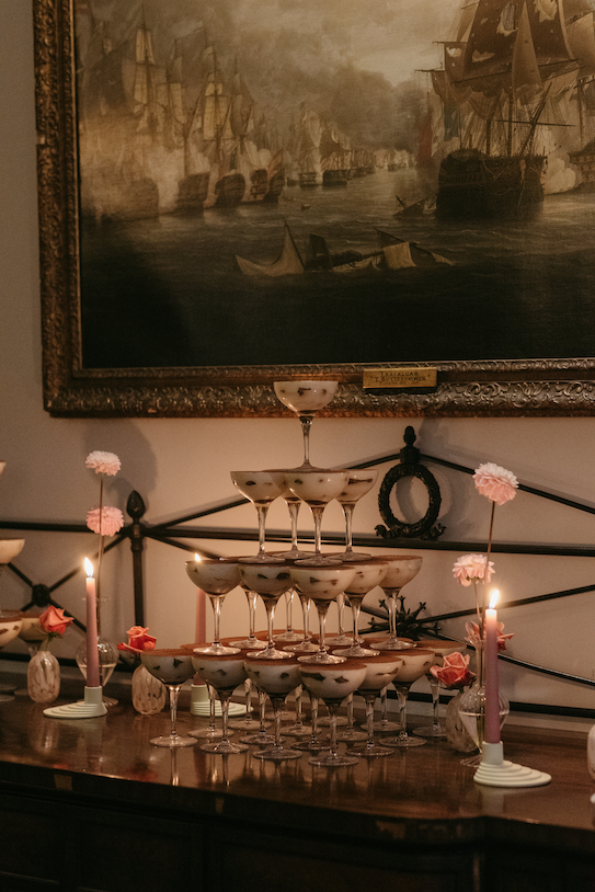 A tiramisu tower surrounded by candlelight.
