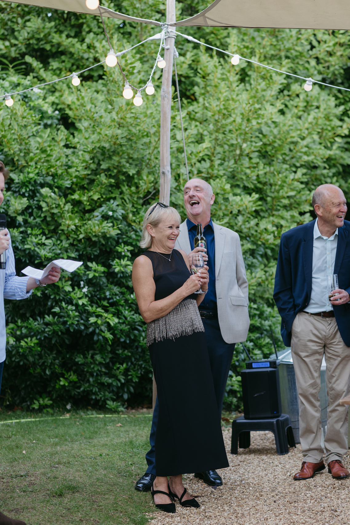 A couple laughing during speeches outside the venue.