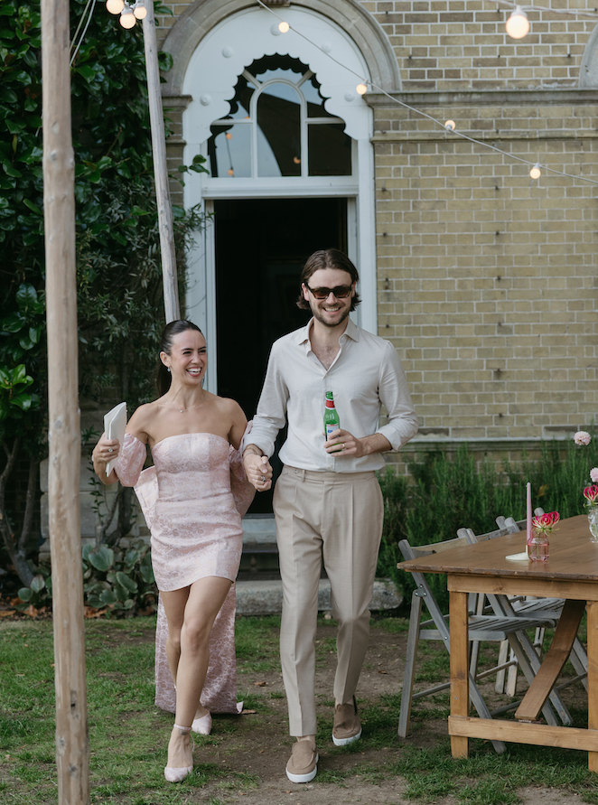 A couple walking into their rehearsal dinner at Pylewell Park.