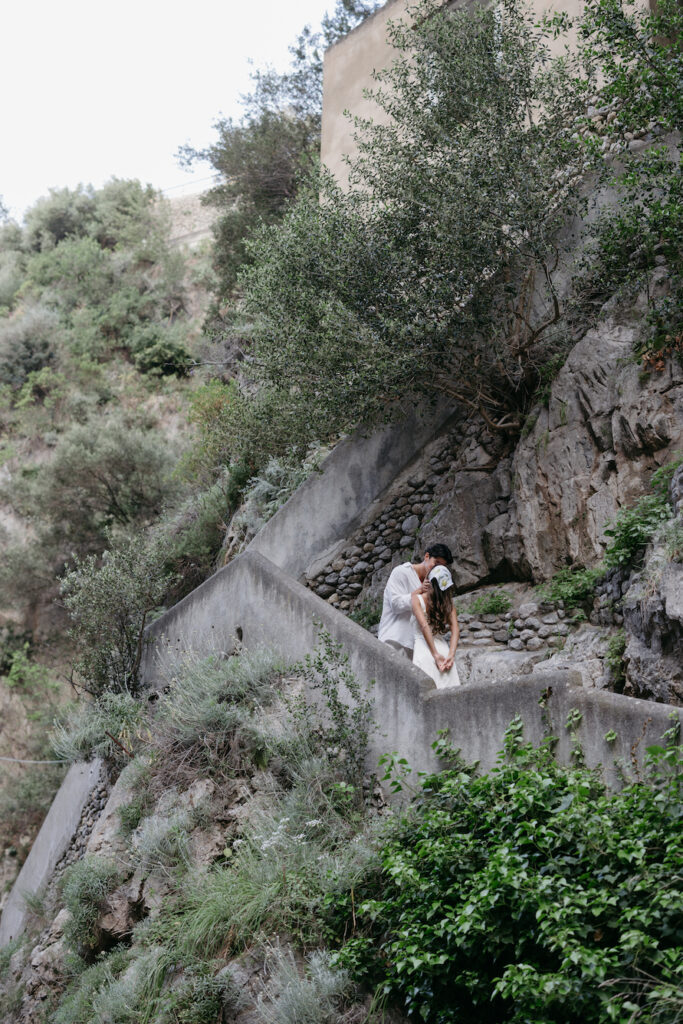 A couple kissing on the stairs at fiordo di furore.